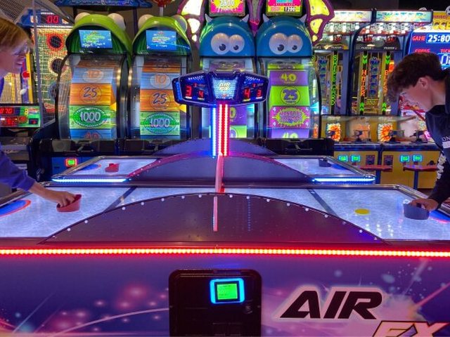 An Air FX air hockey table lit in blue on the GameTime game floor