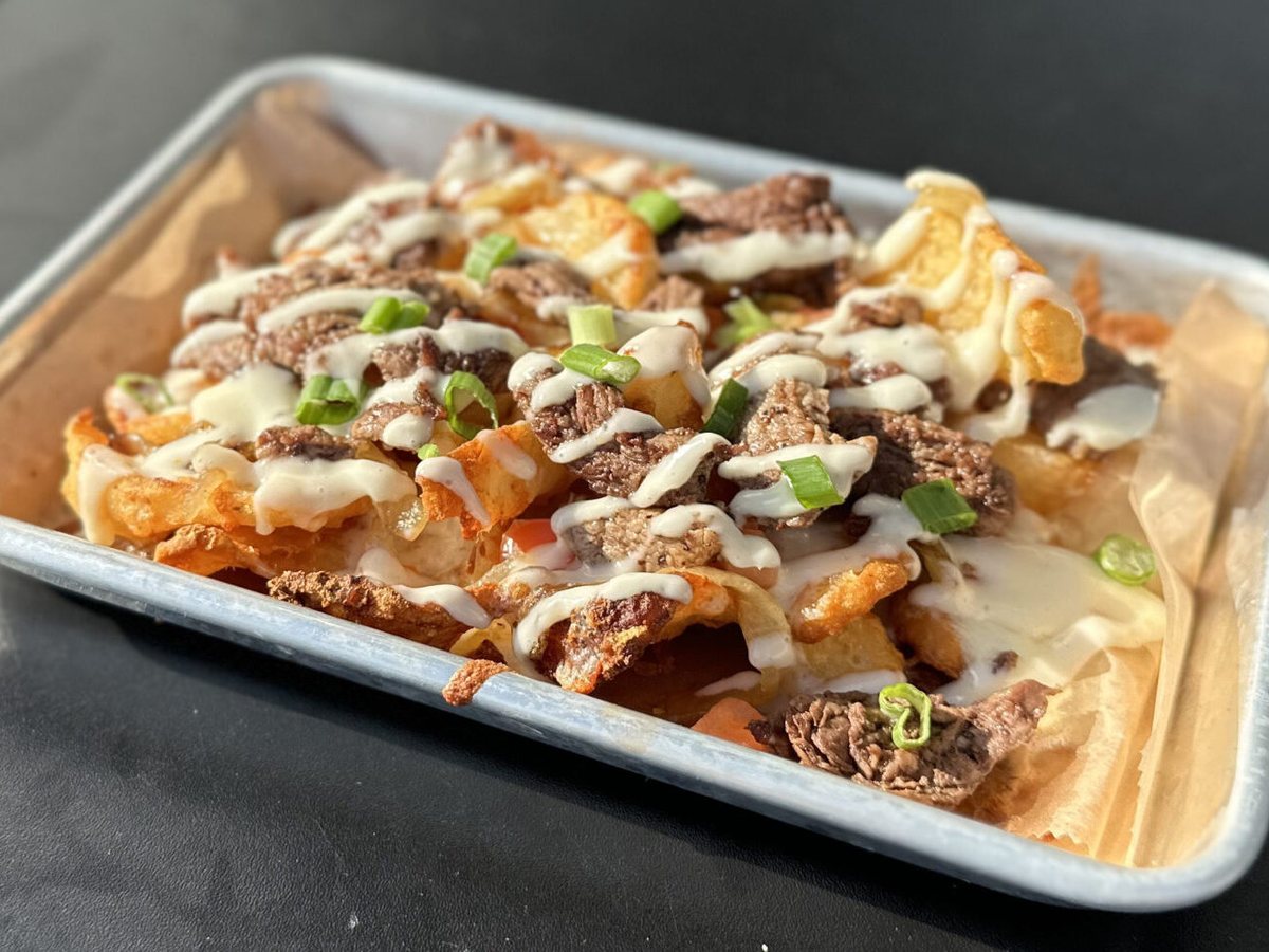 Steak Filet Tip Fries topped with steak, caramelized onions, green onions, cheese sauce and horseradish sauce