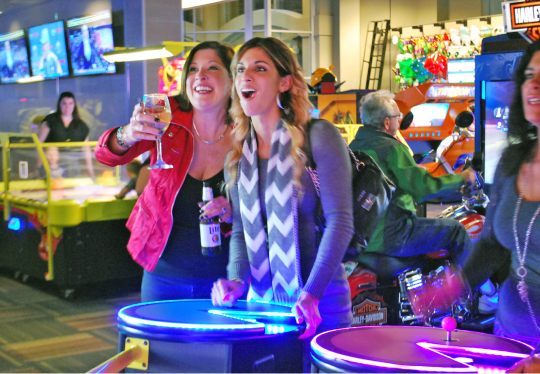 A group of adults gathered around games at a GameTime corporate event