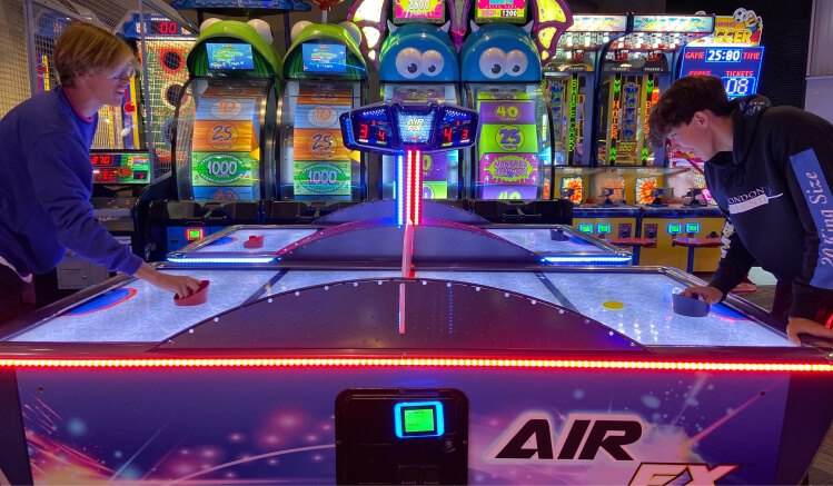 Two players at an air hockey table on the game floor at GameTime
